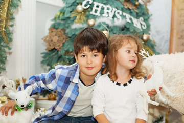 Portrait of a happy children - boy and girl. Little kids in Christmas decorations. Brother and sister