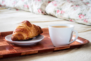 Tasty breakfast to bed. Croissant with coffee.
