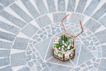 The glass box with wedding rings on stone floor