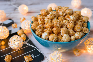 Clapperboard, popcorn, and Christmas garlands glow