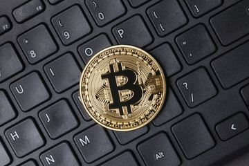Golden bitcoin on keyboard, top view