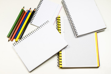 Sensual sketchbook and crayons on a white table. White table and white background.