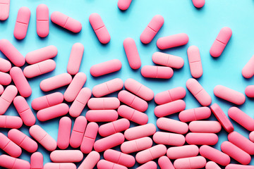 Pink medicine pills on a blue