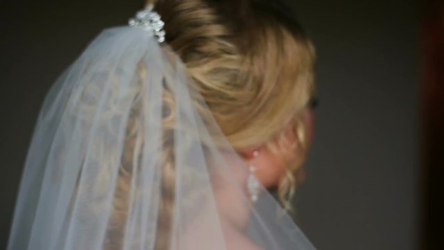 Pretty bride looking out of window and smiling on her wedding day