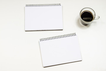 Coffee and sketchbook for drawings. White table. Isolated background.