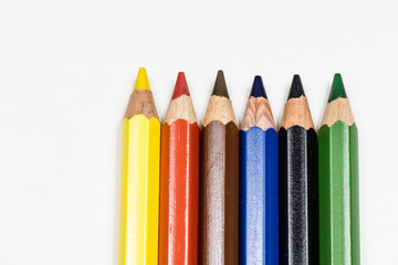 Cute baby pencil crayons on a white table. Isolated background.