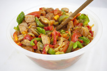 Delicious red souse from sausage, pepper and courgette in the ja