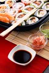 Composition with assorted sushi rolls and bowls of spices