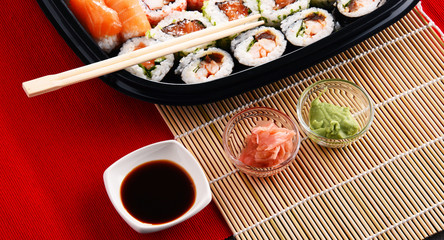 Composition with assorted sushi rolls and bowls of spices