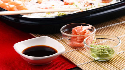 Composition with assorted sushi rolls and bowls of spices