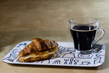 Fresh hot coffee and breakfast on the tray. Wooden table