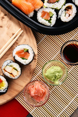 Composition with assorted sushi rolls and bowls of spices