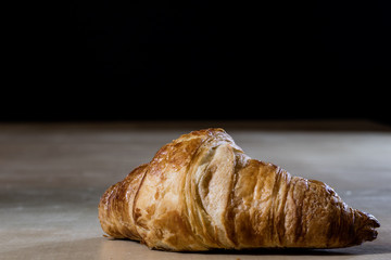 Tasty fresh croissant on a large wooden table.