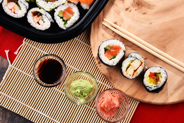 Composition with assorted sushi rolls and bowls of spices