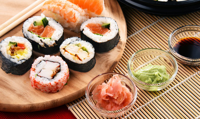 Composition with assorted sushi rolls and bowls of spices