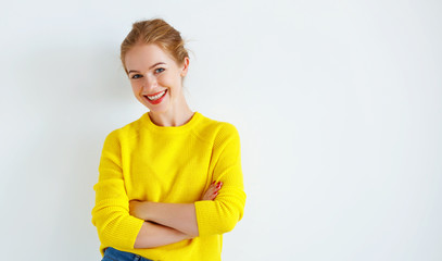 ppy young woman in yellow sweater on white background.