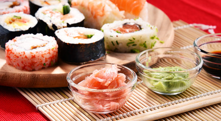 Composition with assorted sushi rolls and bowls of spices