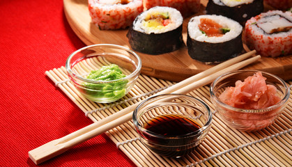 Composition with assorted sushi rolls and bowls of spices