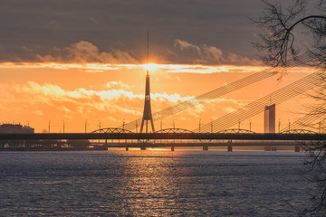 City silhouette of Riga, Latvia in colorful morning sunset. Church towers and popular landmarks in background with stunning yellow sky. 