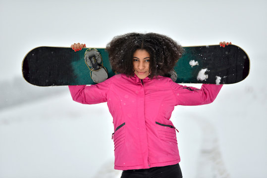 afro woman with snowboard