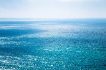 Beautiful seascape in the Atlantic ocean. Divine turquoise sea with white shimmering light on water and the blue shining sky
