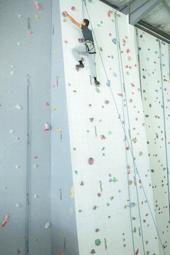 wide view of male climbing on an indoor climbing wall
