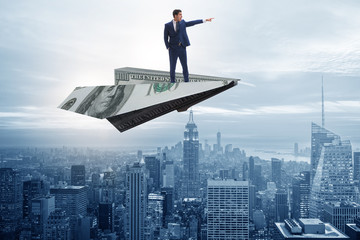 Businessman flying on paper plane in business concept