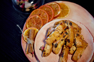 Cookie biscotti on a plate with orange slices. The atmosphere of warmth and comfort