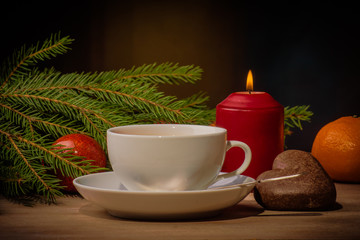 Obraz na płótnie Canvas cup of tea, burning candle and Christmas tree branch in the evening