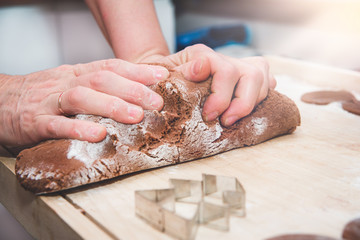 Baking gingerbreads. The family is preparing a gingerbread. The woman kneads the dough. Preparing for Christmas, time for the family, cooking together and baking the concept. 