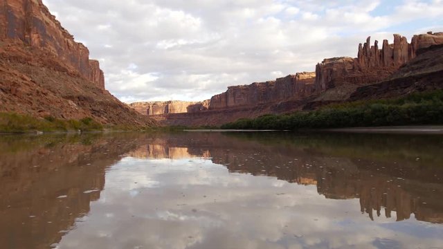 Red rocks float past as the sunrise shines on the Green River.