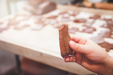 Baking gingerbreads. The family is preparing a gingerbread. The boy is holding a gingerbread man. Preparing for Christmas, time for the family, cooking together and baking the concept. 