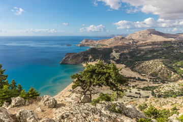 Fototapeta na wymiar Stony landscape and a view of the Tsambika beach on the Rhodes Island, Greece