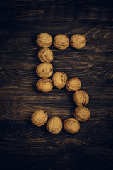 five nuts on wooden background