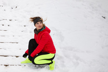 Woman tying sport shoes during winter
