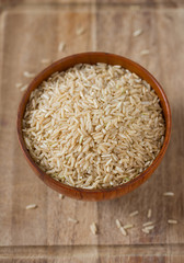 Brown rice in a bowl on wooden ыгкафсу