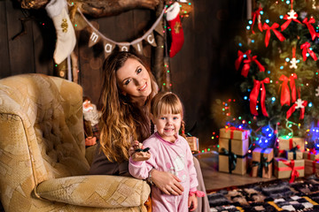 New Year and Christmas 2018. Beautiful mother with her daughter on the background of a Christmas tree and lights