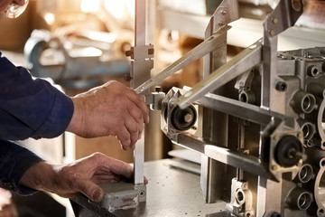 Man is working with a detail. Machine-tool in action.