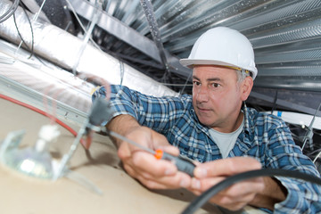 electrician installing ceiling light