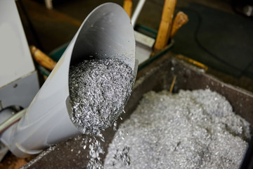 Falling swarf from the tube. Swarf is falling into the container.