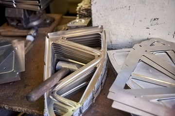 Steel parts and hammer. Tool and parts, workshop table.