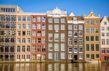 Obraz premium Traditional old buildings and and boats in Amsterdam, Netherlands. Canals of Amsterdam.