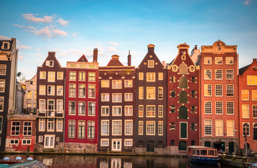 Fototapeta premium Traditional old buildings and boats at sunset in Amsterdam, Netherlands.