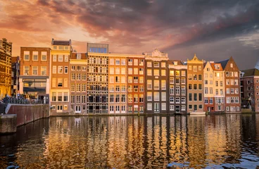 Plexiglas foto achterwand Traditional old buildings and boats at sunset in Amsterdam, Netherlands. © Olena Zn