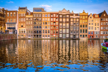 Fototapeta na wymiar Traditional old buildings and boats at sunset in Amsterdam, Netherlands.
