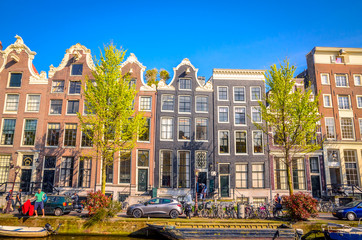 Obraz premium Traditional old buildings and and boats in Amsterdam, Netherlands. Canals of Amsterdam.