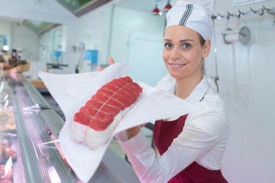 Female butcher showing lean joint of meat