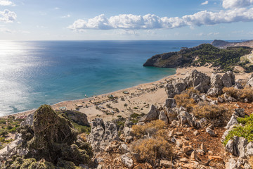 Stony landscape and a view of the Tsambika beach on the Rhodes Island, Greece