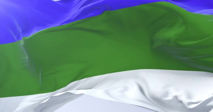 Komi Republic flag waving at wind with blue sky in slow, loop