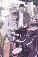 Obraz na płótnie Canvas Boy and father choosing best drum